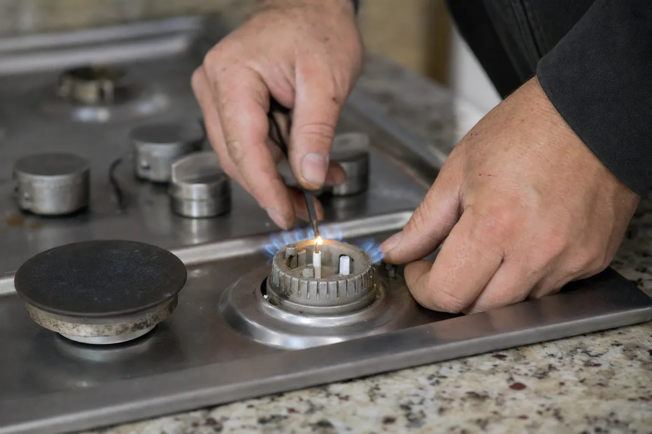 Technician adjusting a gas cooktop burner mid-repair